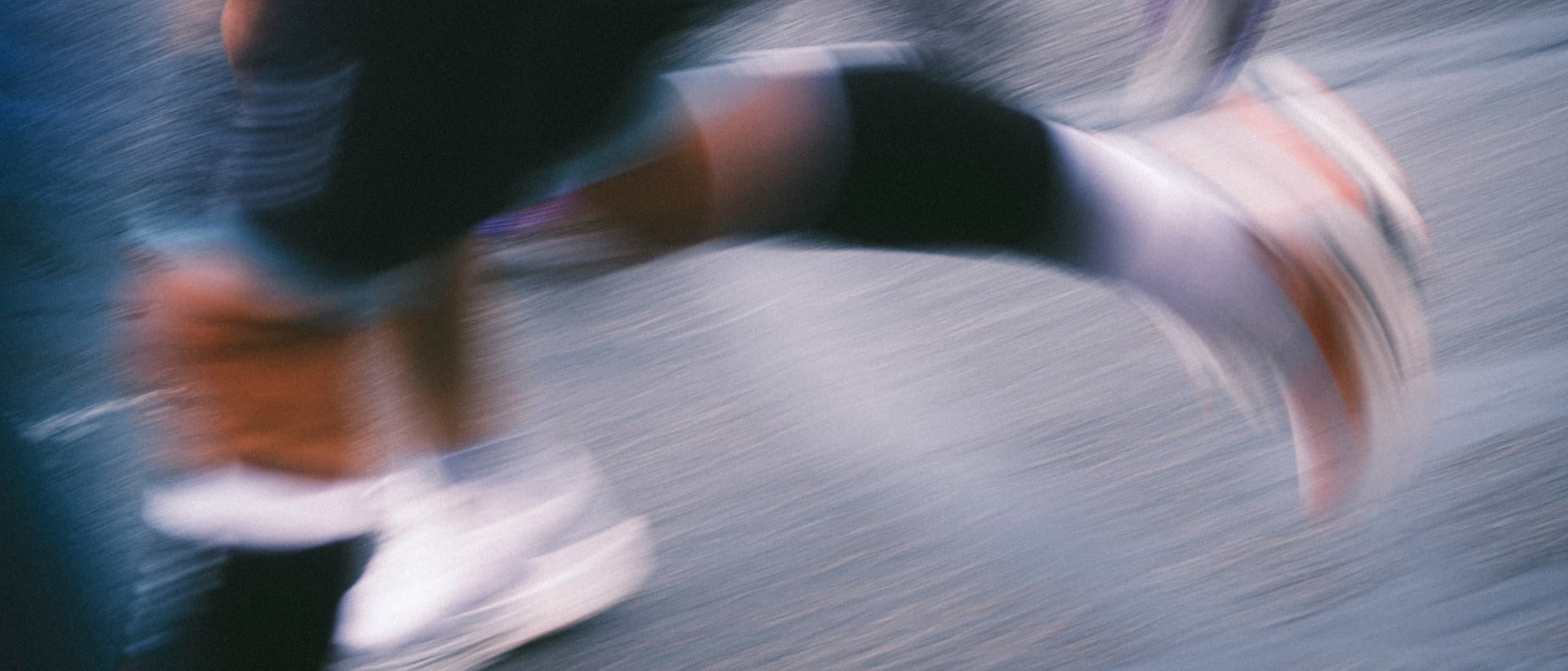 Runners' legs blurred mid-stride on a road